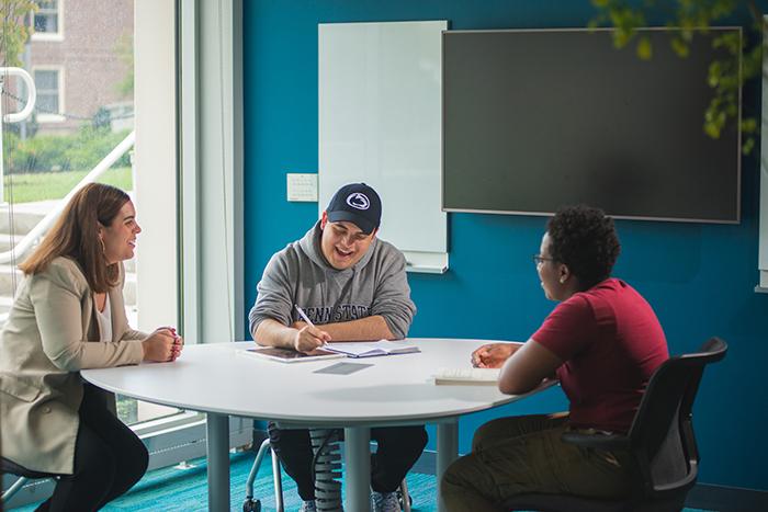 Three students talking and studying